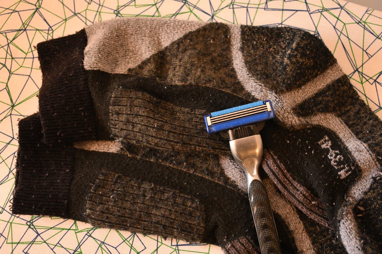 Nassrasierer liegt auf Socken mit Pilling
