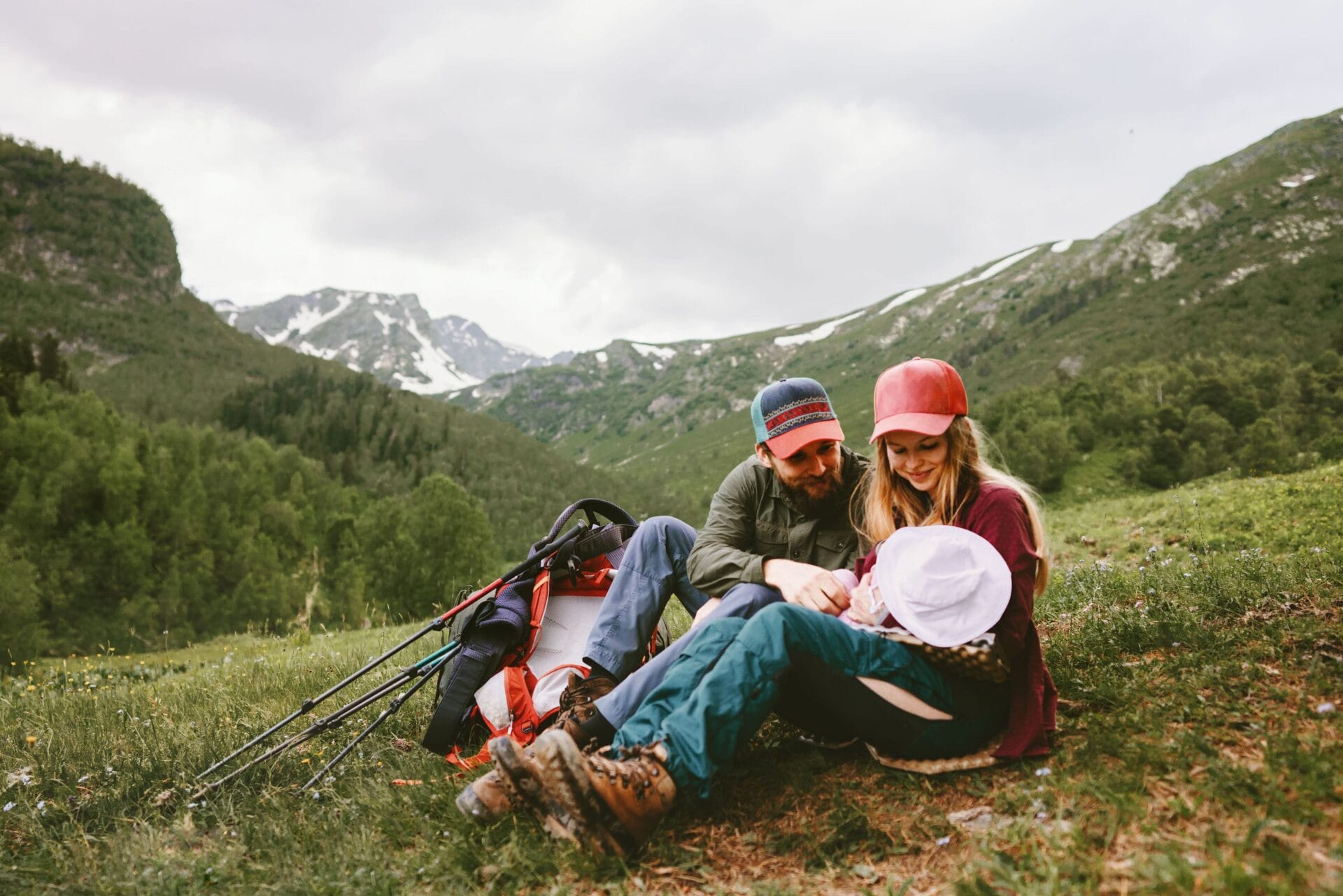 Pärchen sitzt mit ihrem Baby in der Natur.
