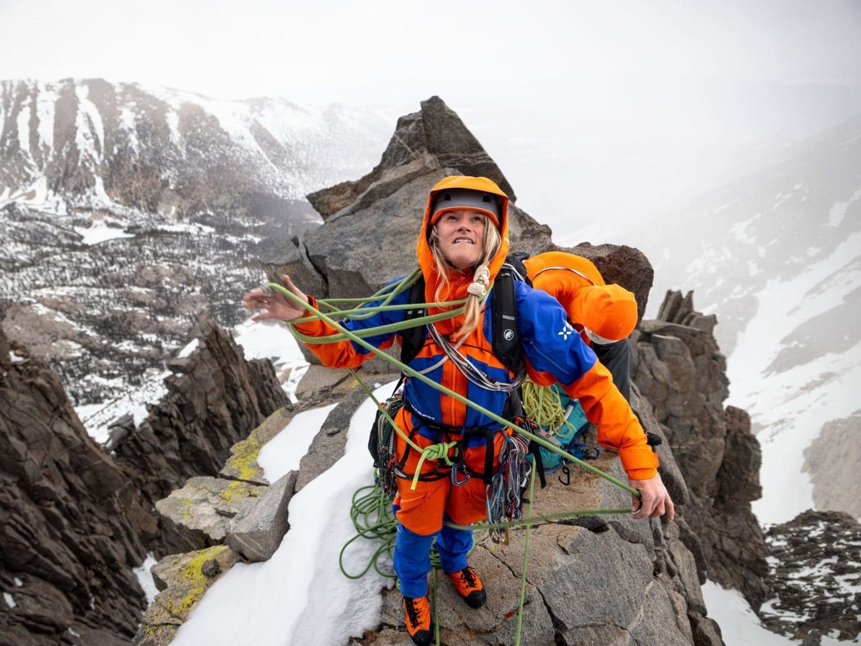 Bergsteigerin in Mammut Eiger Extreme-Kollektion auf einem Bergkamm.