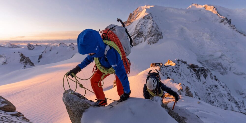 Bergsteiger im Sonnenuntergang auf einem verschneiten Bergkamm